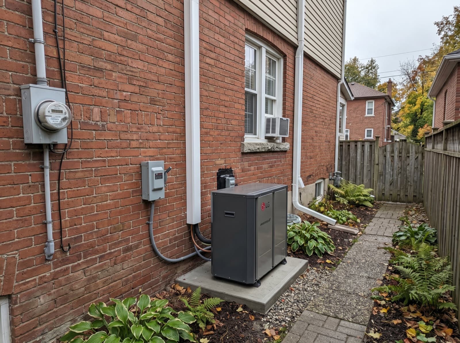 Cold-climate heat pump beside a brick house.