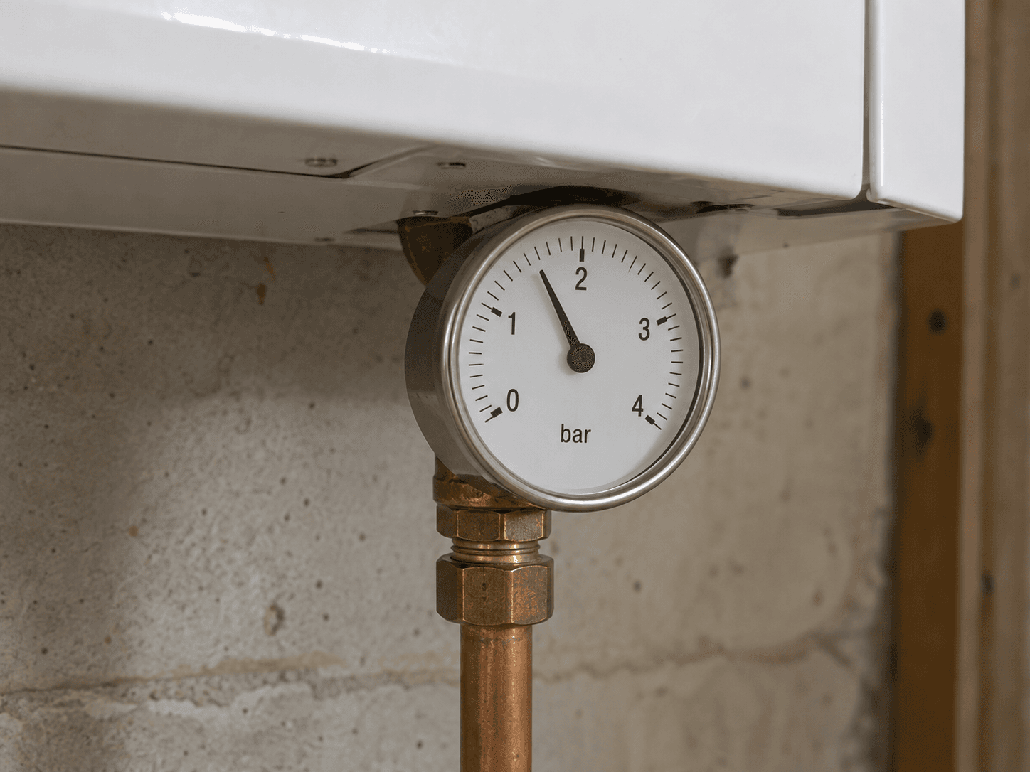 A single-scale pressure gauge marked in bar beneath a closed boiler cabinet.