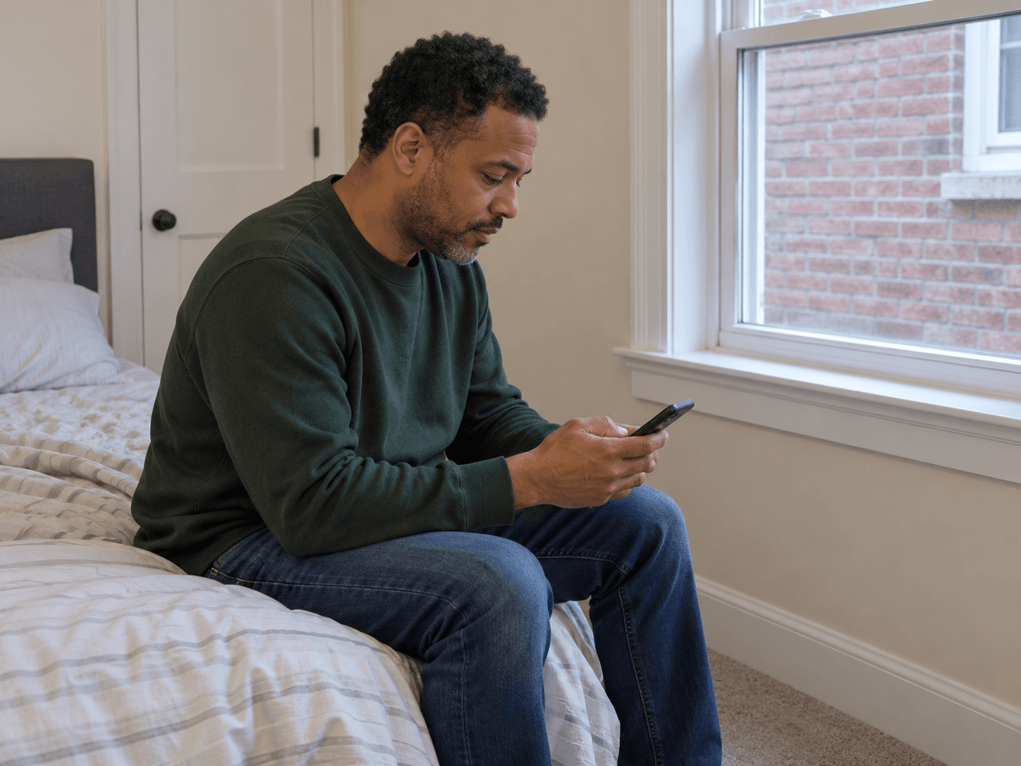 A homeowner records the time on a phone near the bedroom's outside wall.