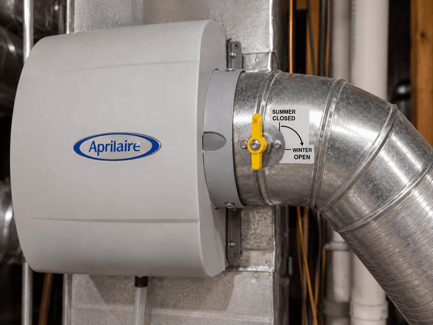A labelled seasonal damper handle sits on the round bypass duct beside a closed humidifier.
